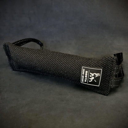 Close-up of a black Bestia Dog Sport Bite Tug for dog training, showing the durable woven fabric, the white brand logo, and two heavy-duty nylon handles on a dark background.