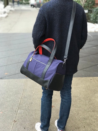 Person carrying the Canopy Verde Dekalb duffle bag over the shoulder while walking in the city