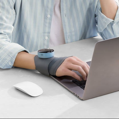 Close-up of a person typing on a laptop while wearing the Pursonic EMS wrist massager to reduce strain and improve comfort