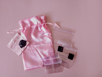 Pink satin jewelry travel organizer set with multiple soft pouches and clear zip cases laid out flat
