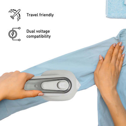 Compact Pursonic mini travel iron smoothing a shirt sleeve, highlighting portable size and dual-voltage travel design.