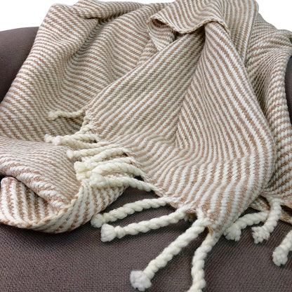 Textured blanket with tassels on a brown surface